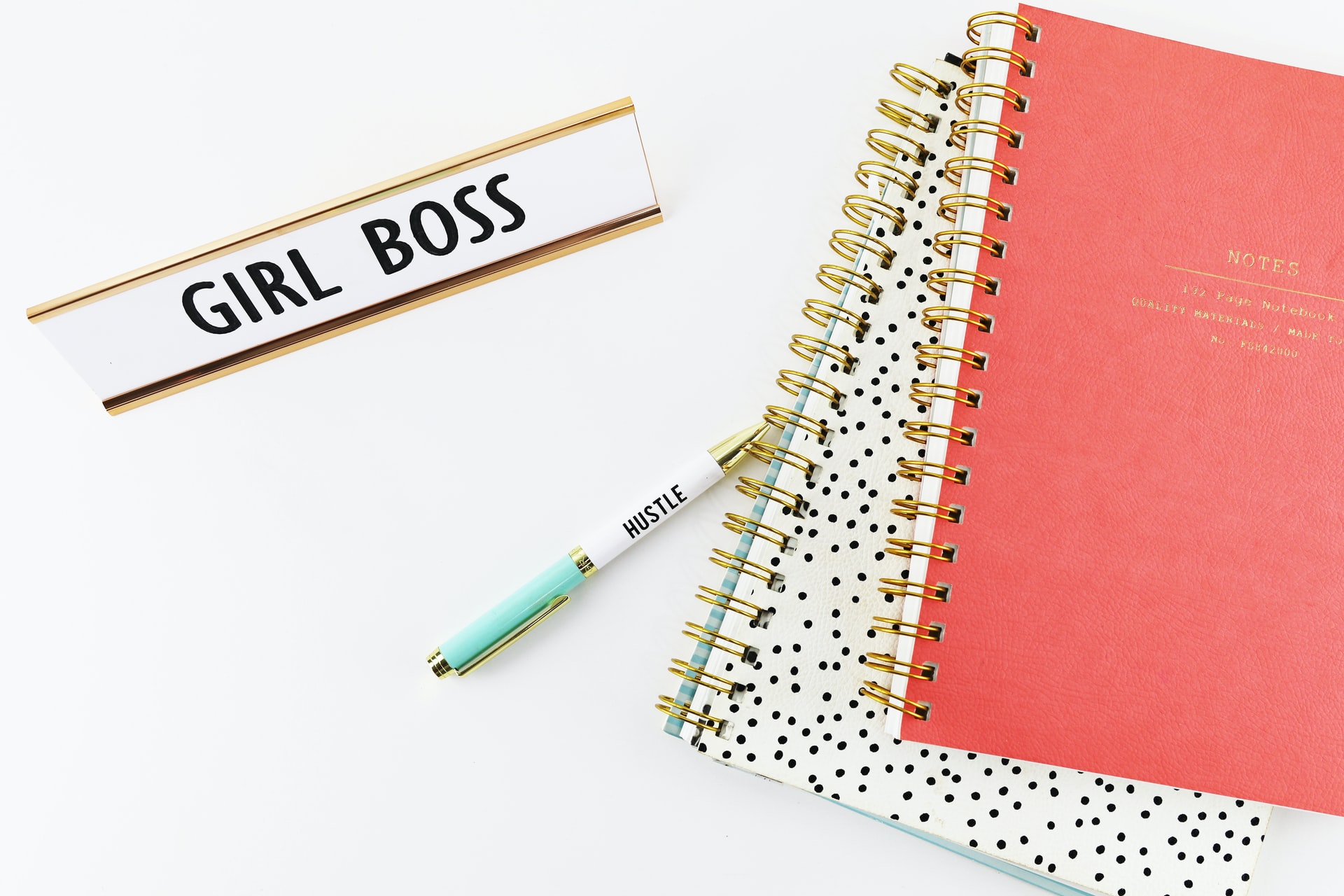 How do bloggers get paid? Picture of some notebooks a pen and a plaque that says Girl Boss