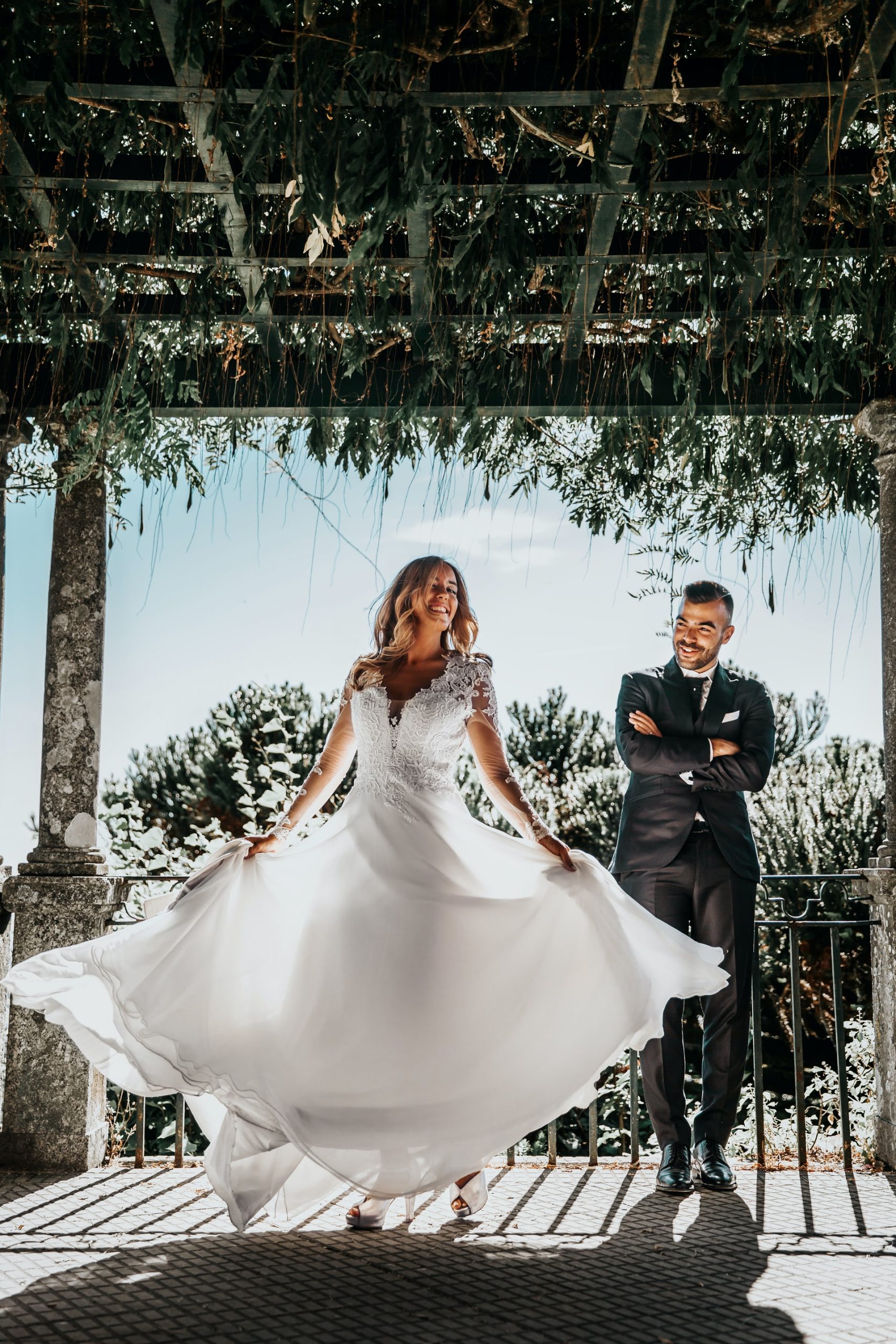 Couple on their wedding day in traditional clothes on a stand with loads of foliage