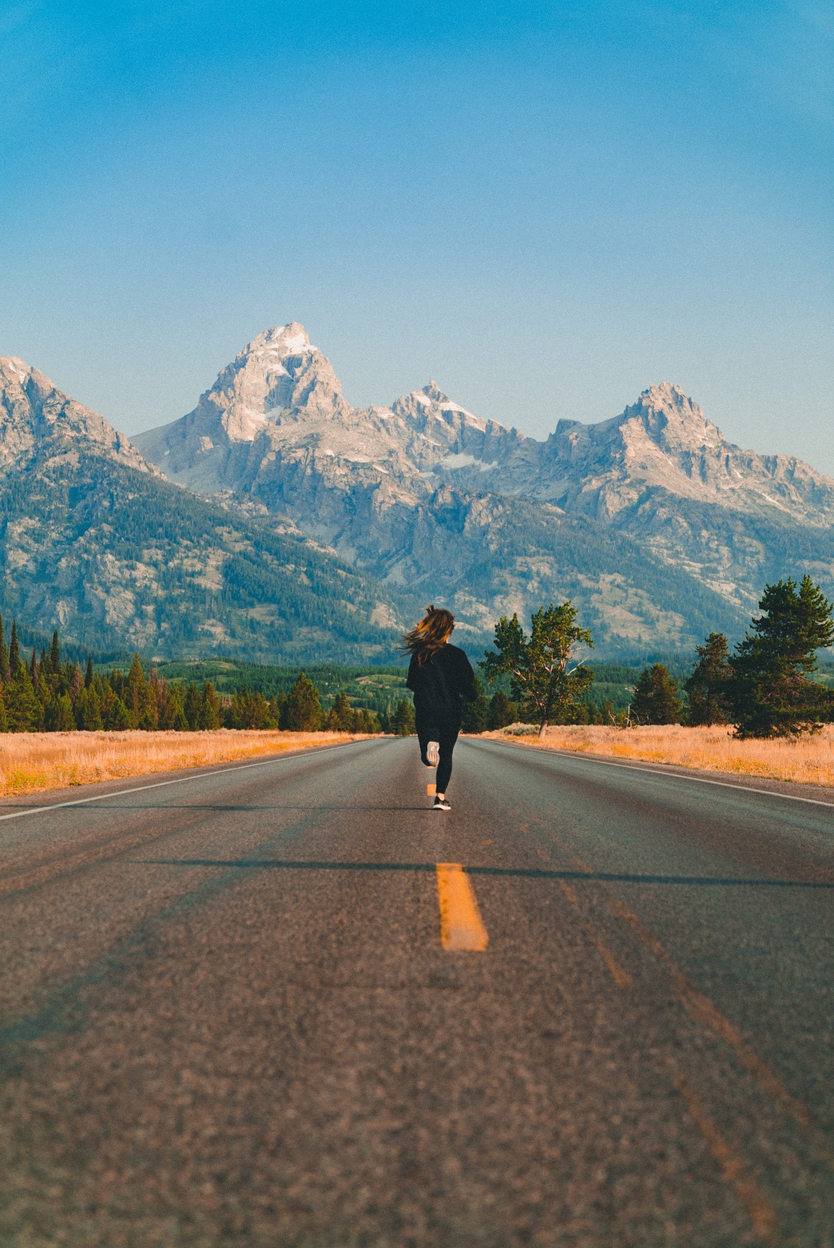 woman running down a long road