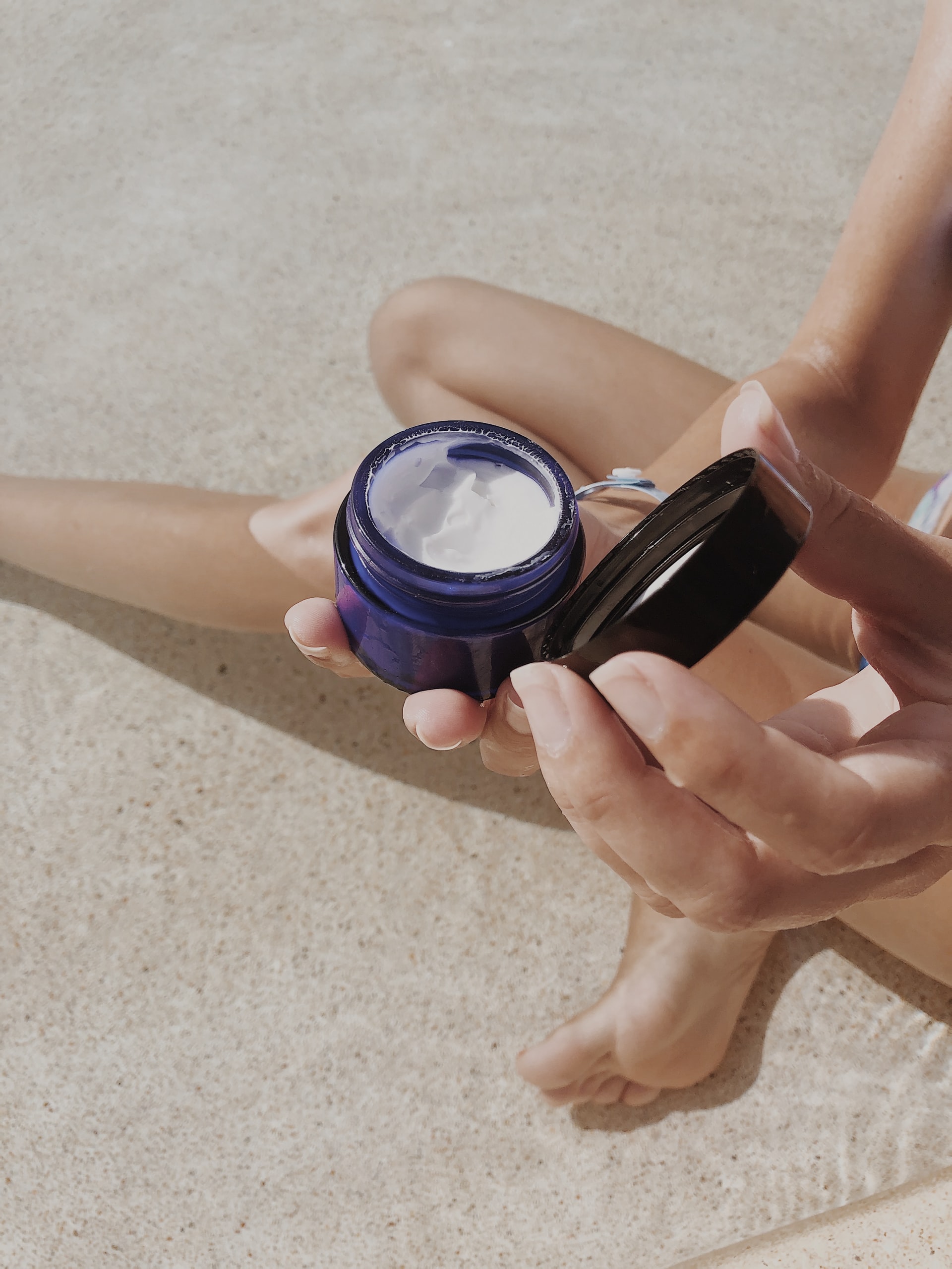 oitnment in a blue pot, held by a woman