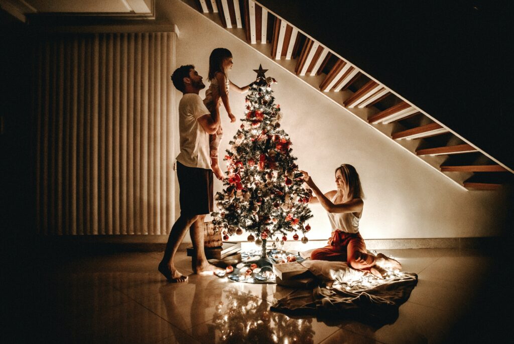 family decorating a christmas tree